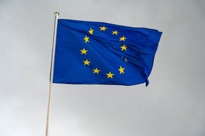 Zastava EU se vijori na vjetru sa tamnim oblačnim nebom u pozadini. EU zastava na jarbolu.