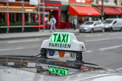 Pariz, Francuska: znak za taksi na krovu automobila. Taksi na ulici. Taxi stajalište u gradu. Prijevoz.