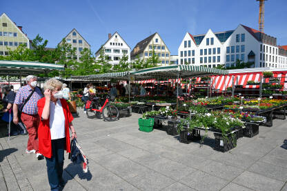 Ulm, Njemačka: Tržnica voća, povrća i cvijeća. Ljudi na ulici sa maskama za lice. Kupci na uličnoj pijaci.