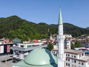 Džamija i crkva u centru grada. Konjic, BiH. Minaret, crkveni toranj i zgrade u gradu.