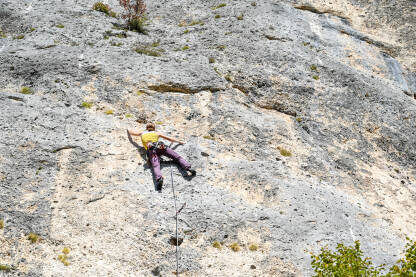 Djevojka se penje na stijeni.