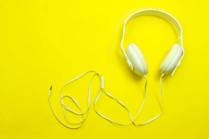 Bijele slušalice na žutoj pozadini