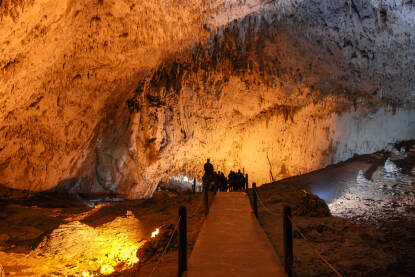 Unutrašnjost pećine ukrašena stalaktitom. Kamene i kamene formacije u pećini. Mineralne i kristalne formacije. Speleologija.