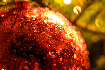 Sjajna kuglica, izbliza. Okićeno novogodišnje i božićno drvce kod kuće. Šareni ukrasi i upaljene lampice na drvcu. Sretna Nova godina.