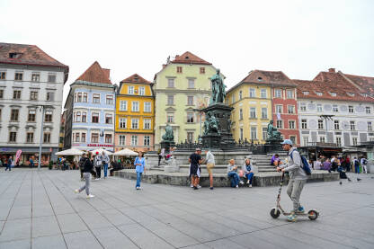 Graz, Austrija: Grupa ljudi na glavnom trgu u centru grada. Historijske zgrade na glavnom trgu ili Hauptplatzu. Stari grad Graz. Erzherzog-Johann-Brunnen fontana.