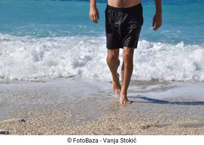 Zgodan muškarac izlazi iz mora.