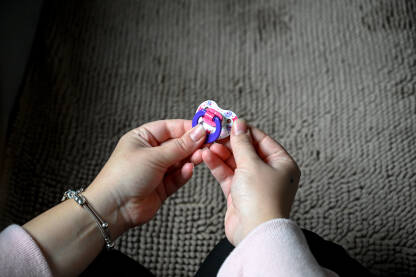 Majka drži cuclu u rukama. Majka drži cuclu u rukama. Mama i beba. Roditeljstvo.