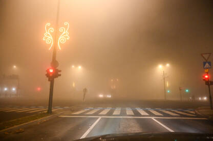 Veliko zagađenje zraka. Vožnja automobila po maglovitom vremenu. Teški uslovi za vožnju noću. Pogled na cestu kroz vjetrobransko staklo automobila. Magla.
​