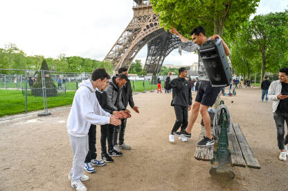 Pariz, Francuska: Grupa turista pjeva i pleše u blizini Eiffelovog tornja. Arapi plešu u parku.
