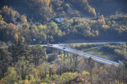 Titov most u Jajcu sa slabim saobraćajem sa zelenom površinom oko njega.