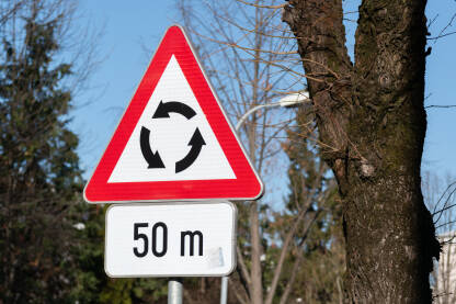 Znak za raskrsnicu sa kružnim tokom saobraćaja sa dopunskom tablom koja označava udaljenost od znaka do raskrsnice