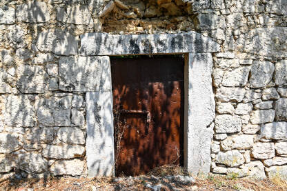 Metalna vrata na staroj kamenoj kući.