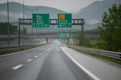 Odvajanje na autoputu za Zenicu i Doboj, te Foču i Sarajevo Vožnja automobila po mokroj i skliskoj autocesti. Vlažna asfaltna cesta. Riskantna i opasna vožnja cestom.