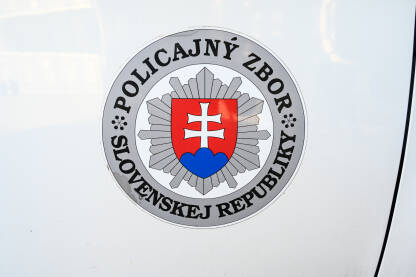 Policijski auto u Slovačkoj. Grb i naziv slovačke policije. Pogled sa strane na policijsko vozilo sa natpisom "Policija".