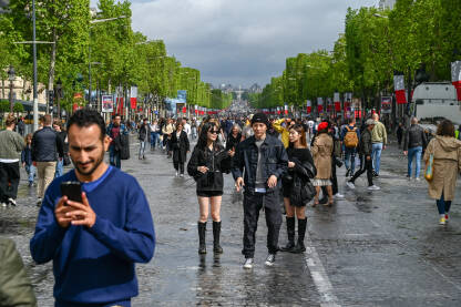 Pariz, Francuska: Turisti šetaju čuvenom avenijom Champs-Élysées. Ljudi šetaju ulicom u blizini poznate znamenitosti.
