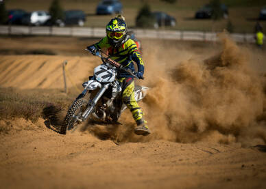 Vozač cross motora tokom trke. Motocross trka. Takmičenje u vožnji cross motora.