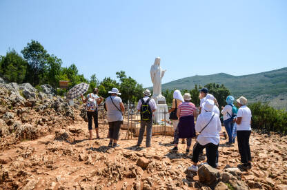 Grupa katoličkih hodočasnika se moli na svetom mjestu. Hodočasnici u Međugorju, Bosna i Hercegovina.