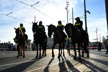 Amsterdam, Nizozemska: Policajci na konjima u patroli u gradu. Policijska konjica. Četiri policijska jahača na konjima.