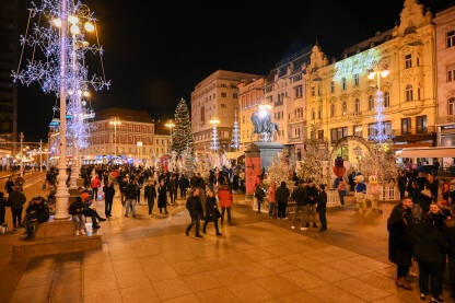 Zagreb, Hrvatska. Advent u Zagrebu. Praznične gužve u čarobnom adventskom slavlju u okićenom gradu. Ljudi šetaju kroz blistave praznične ulice i trgove tokom praznika. Praznični ukrasi.