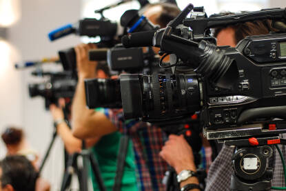 Konferencija za novinare. Snimanje i praćenje medijskog događaja video kamerom. Novinarstvo. Profesionalni snimatelj snima intervju.