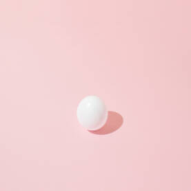 Bijelo jaje na ružičastoj pozadini.