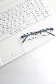 Povešina radnog stola, sa laptopom i naočalama.