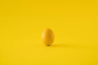 Žuto jaje na žutoj pozadini. Čestitka za Uskrs / Vaskrs.