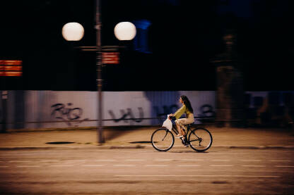 Žena vozi biciklo tokom noći