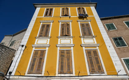 Prozori i narandžasta fasada na zgradi. Stambena zgrada u Šibeniku, Hrvatska.