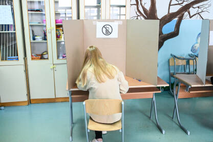Djevojka glasa na izborima. Birači na dan izbora.