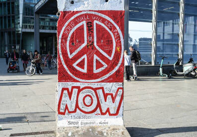 Berlin, Njemačka: Znak mira na bivšem Berlinskom zidu. Očuvani dio Berlinskog zida. Berlinski zid je bio betonska barijera koja je dijelila grad na istok i zapad tokom hladnog rata.