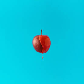 Svježa jabuka umočena u crvenu boju.