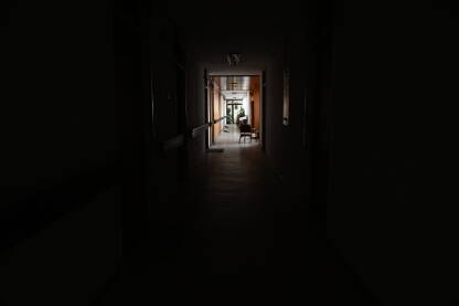 Dugi mračni hodnik u zgradi. Neosvjetljeni hodnik u školi ili bolnici.