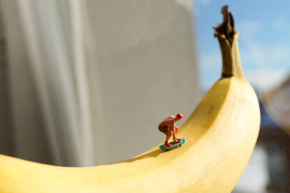 Mala figurica covijeka koji vozi skejt na banani.