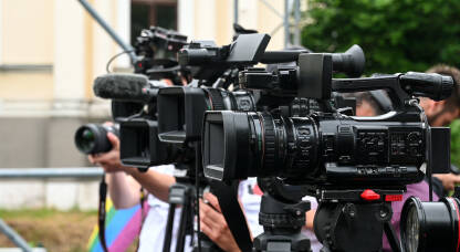 Kamere na konferenciji za novinare. Snimanje press događaja video kamerom. Novinarstvo. Profesionalni snimatelji snimaju govore.