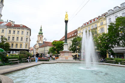 Graz, Austrija: Fontana i spomenik u centru grada. Ljudi na ulici.