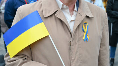 Čovjek s ukrajinskom zastavom na protestu za mir. Zastava Ukrajine.
