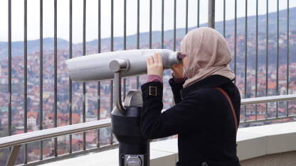 Žena gleda kroz panoramski durbin na Avaz Twist Tower vidikovcu.