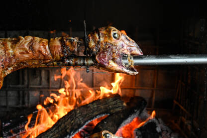 Pečena jagnjetina. Ovce na ražnju iznad vatre u restoranu. Pečeno meso.