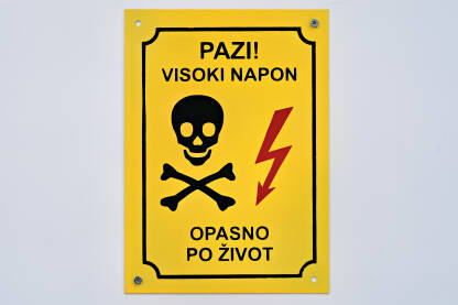 Znak za opasnost od strujnog udara. Znak upozorenja na trafostanici. Natpis: Pazi! Visoki napon. Opasno po život.